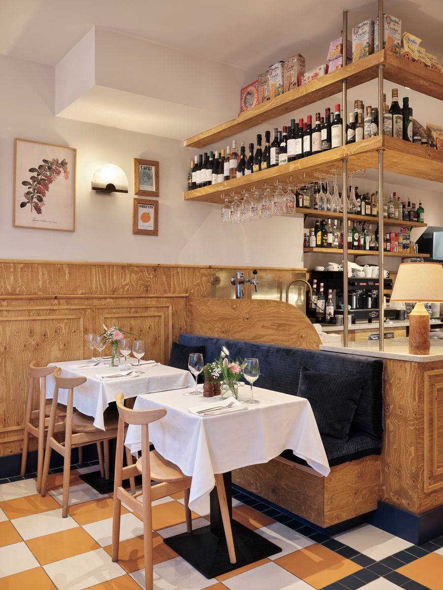 The bar with shelves of wine and spirits beside a cosy banquette