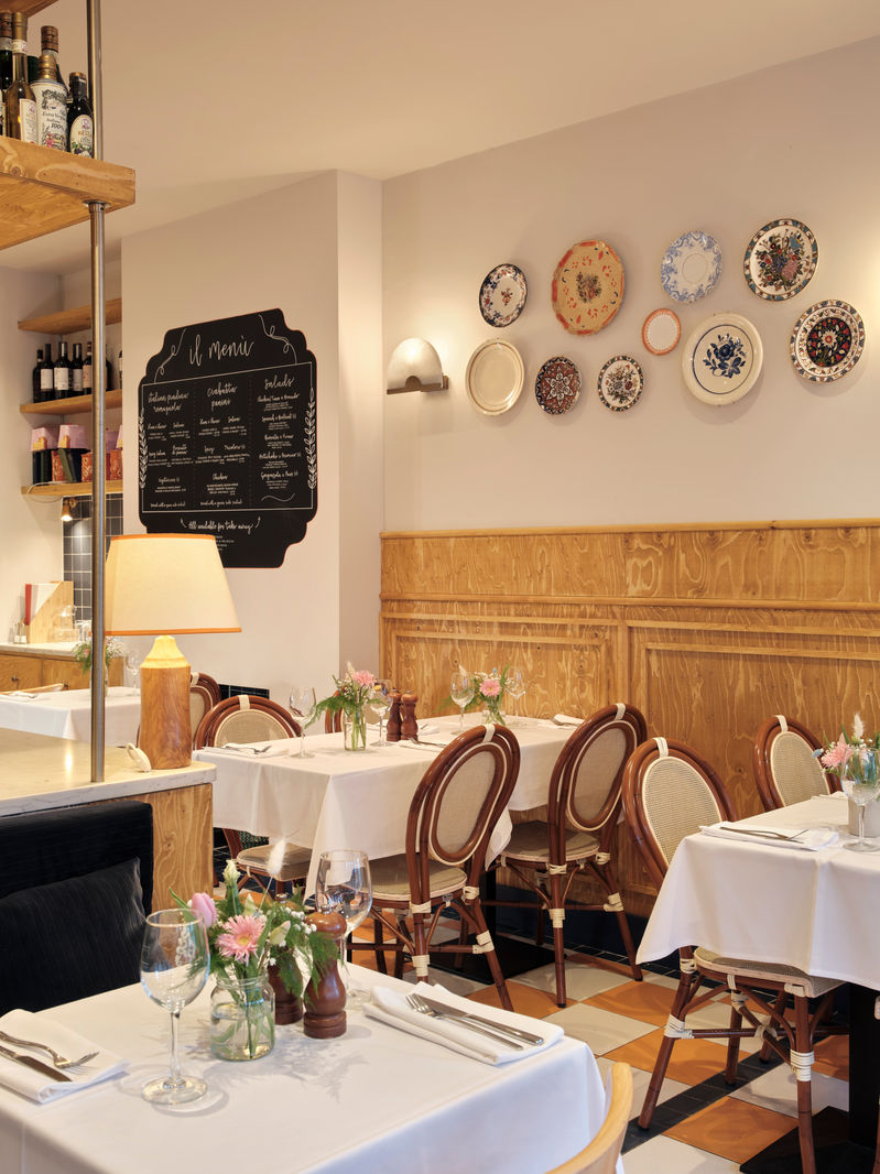Dining room with vintage plates on the wall and a chalkboard menu